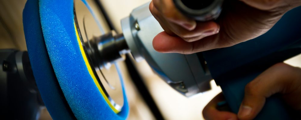 Someone using a handheld car polishing machine